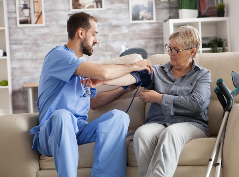 Caregiver checking a senior resident's blood pressure